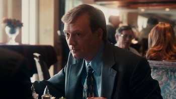 Movie still from “The Informant!” (2009), directed by Steven Soderbergh – A person wearing a suit and tie; Close Up shot, Over the shoulder angle