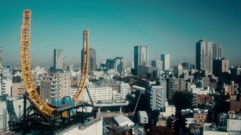 Movie still from “The Informant!” (2009), directed by Steven Soderbergh – A view of a city with a crane in the middle of it; Extreme Wide shot, High angle