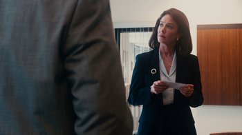 Movie still from “The Informant!” (2009), directed by Steven Soderbergh – A woman in a suit holding a piece of paper in her hand; Medium shot, Over the shoulder angle