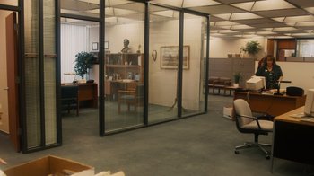 Movie still from “The Informant!” (2009), directed by Steven Soderbergh – An empty office with glass walls and a desk with a chair; Extreme Wide shot, High angle