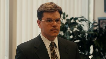 Movie still from “The Informant!” (2009), directed by Steven Soderbergh – A man in a suit and tie wearing glasses; Close Up shot, Low angle
