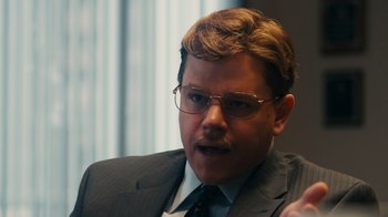 Movie still from “The Informant!” (2009), directed by Steven Soderbergh – A person wearing a suit and glasses; Close Up shot, Over the shoulder angle