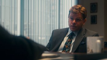 Movie still from “The Informant!” (2009), directed by Steven Soderbergh – A man sitting at a table in front of a window; Medium shot, Over the shoulder angle