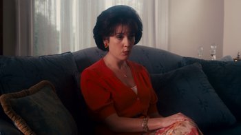 Movie still from “The Informant!” (2009), directed by Steven Soderbergh – A woman sitting on top of a couch in a living room; Close Up shot, High angle