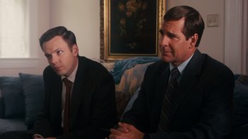 Movie still from “The Informant!” (2009), directed by Steven Soderbergh – A couple of men sitting next to each other in a room; Medium shot, Over the shoulder angle