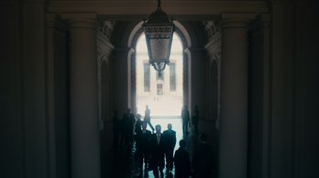 Movie still from “The Informant!” (2009), directed by Steven Soderbergh – A group of people standing under a lit up light; Extreme Wide shot, Low angle