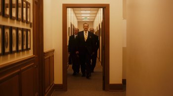 Movie still from “The Informant!” (2009), directed by Steven Soderbergh – A group of men walking down a hall way; Wide shot, Low angle