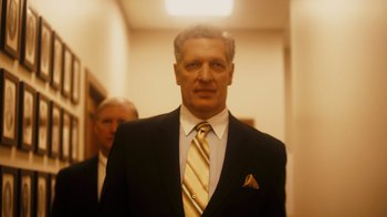 Movie still from “The Informant!” (2009), directed by Steven Soderbergh – A man in a suit and tie standing in a hallway; Medium shot, Low angle
