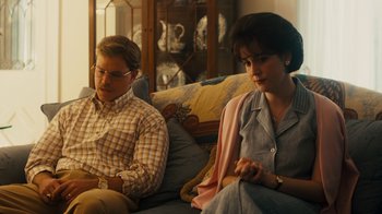 Movie still from “The Informant!” (2009), directed by Steven Soderbergh – A man and a woman sitting on a couch next to each other; Medium shot, Over the shoulder angle