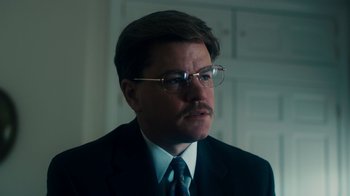 Movie still from “The Informant!” (2009), directed by Steven Soderbergh – A person wearing a suit and tie; Close Up shot, Low angle