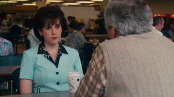 Movie still from “The Informant!” (2009), directed by Steven Soderbergh – A woman is sitting at a table with a cup of coffee; Medium shot, Over the shoulder angle