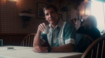 Movie still from “The Informant!” (2009), directed by Steven Soderbergh – A man sitting at a table drinking a cup of coffee; Medium shot, Over the shoulder angle