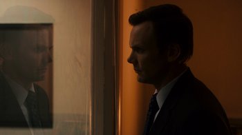 Movie still from “The Informant!” (2009), directed by Steven Soderbergh – A man in a suit looking out a window; Close Up shot, Over the shoulder angle