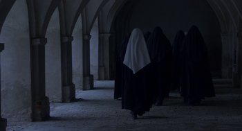 Movie still from “The Innocents” (2016), directed by Anne Fontaine – A group of people walking down a hall way; Wide shot, Low angle