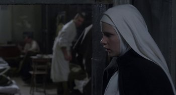 Movie still from “The Innocents” (2016), directed by Anne Fontaine – A woman wearing a nun's outfit in front of a mirror; Close Up shot, Over the shoulder angle