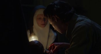 Movie still from “The Innocents” (2016), directed by Anne Fontaine – A woman and a child are looking at something; Close Up shot, Over the shoulder angle