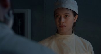 Movie still from “The Innocents” (2016), directed by Anne Fontaine – A woman wearing a white hat looking into a mirror; Close Up shot, Over the shoulder angle
