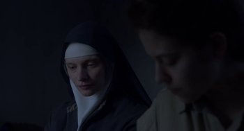 Movie still from “The Innocents” (2016), directed by Anne Fontaine – A woman in a nun's habit looking at a man in a dark room; Close Up shot, Low angle