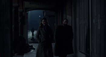 Movie still from “The Innocents” (2016), directed by Anne Fontaine – A man and a woman walking down a street; Wide shot, Low angle