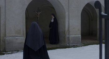 Movie still from “The Innocents” (2016), directed by Anne Fontaine – A nun and a cross in a courtyard; Wide shot, High angle