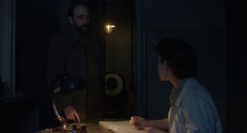 Movie still from “The Innocents” (2016), directed by Anne Fontaine – A man and a woman are standing in the dark; Medium shot, Over the shoulder angle