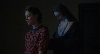 Movie still from “The Innocents” (2016), directed by Anne Fontaine – A nun and a woman standing next to each other; Medium shot, Low angle