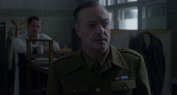 Movie still from “The Innocents” (2016), directed by Anne Fontaine – A person wearing a military uniform; Close Up shot, Over the shoulder angle