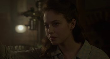 Movie still from “The Innocents” (2016), directed by Anne Fontaine – A young woman is looking into the camera; Close Up shot, Over the shoulder angle