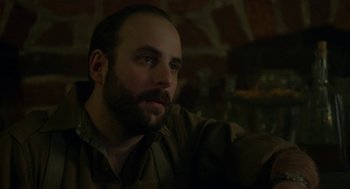 Movie still from “The Innocents” (2016), directed by Anne Fontaine – A man with a goatee and a beard looking to his left; Close Up shot, Low angle