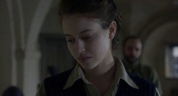 Movie still from “The Innocents” (2016), directed by Anne Fontaine – A young woman is looking down at her face; Close Up shot, Over the shoulder angle