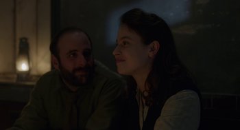 Movie still from “The Innocents” (2016), directed by Anne Fontaine – A man and a woman sitting next to each other in the dark; Close Up shot, Over the shoulder angle
