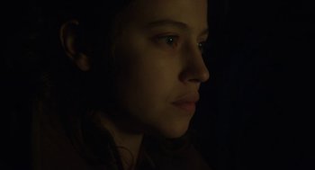 Movie still from “The Innocents” (2016), directed by Anne Fontaine – A woman with green eyes is in the dark; Close Up shot, Low angle