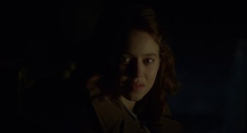 Movie still from “The Innocents” (2016), directed by Anne Fontaine – A woman with red curly hair is looking at the camera; Close Up shot, Over the shoulder angle