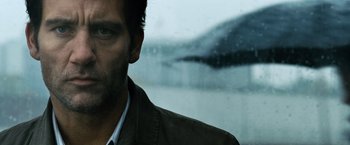 Movie still from “The International” (2009), directed by Tom Tykwer – A person looking out of a window; Close Up shot, Over the shoulder angle