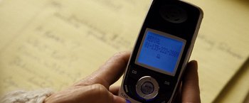 Movie still from “The International” (2009), directed by Tom Tykwer – A person holding a cell phone in their hand; Extreme Close Up shot, High angle