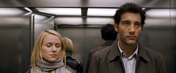 Movie still from “The International” (2009), directed by Tom Tykwer – A man and a woman are standing in an elevator; Close Up shot, Over the shoulder angle