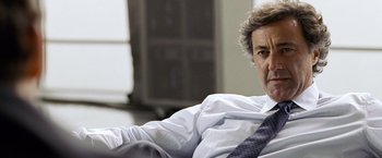 Movie still from “The International” (2009), directed by Tom Tykwer – A person wearing a suit and tie; Close Up shot, Low angle