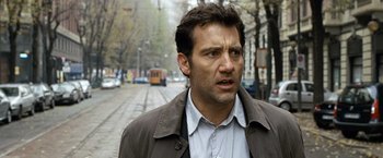 Movie still from “The International” (2009), directed by Tom Tykwer – A person walking on a street; Close Up shot, Over the shoulder angle
