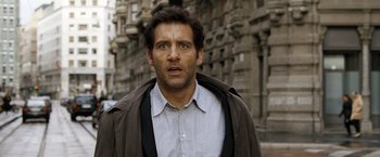 Movie still from “The International” (2009), directed by Tom Tykwer – A person wearing a jacket on a city street; Close Up shot, Over the shoulder angle