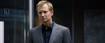 Movie still from “The International” (2009), directed by Tom Tykwer – A person wearing a suit and tie; Close Up shot, Low angle