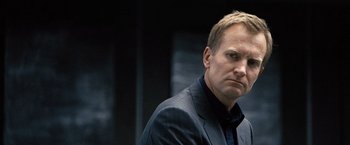 Movie still from “The International” (2009), directed by Tom Tykwer – A man in a suit and tie; Close Up shot, Low angle