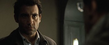 Movie still from “The International” (2009), directed by Tom Tykwer – A person wearing a jacket; Close Up shot, Over the shoulder angle