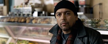 Movie still from “The International” (2009), directed by Tom Tykwer – A person wearing a hat and a scarf; Close Up shot, Low angle