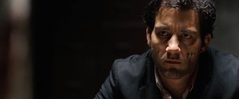 Movie still from “The International” (2009), directed by Tom Tykwer – A person wearing a suit and tie; Close Up shot, Low angle