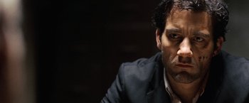 Movie still from “The International” (2009), directed by Tom Tykwer – A person wearing a suit and tie; Close Up shot, Low angle