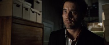 Movie still from “The International” (2009), directed by Tom Tykwer – A person wearing a suit and tie; Close Up shot, Low angle