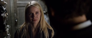 Movie still from “The International” (2009), directed by Tom Tykwer – A person with long blonde hair; Close Up shot, Over the shoulder angle