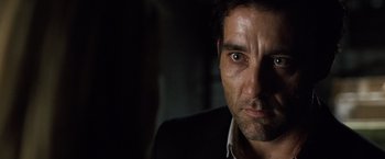 Movie still from “The International” (2009), directed by Tom Tykwer – A man's face in the dark; Close Up shot, Over the shoulder angle