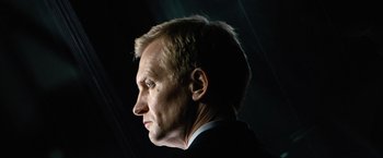 Movie still from “The International” (2009), directed by Tom Tykwer – A person wearing a suit and tie; Close Up shot, Low angle