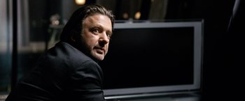 Movie still from “The International” (2009), directed by Tom Tykwer – A person wearing a suit and tie; Close Up shot, Low angle